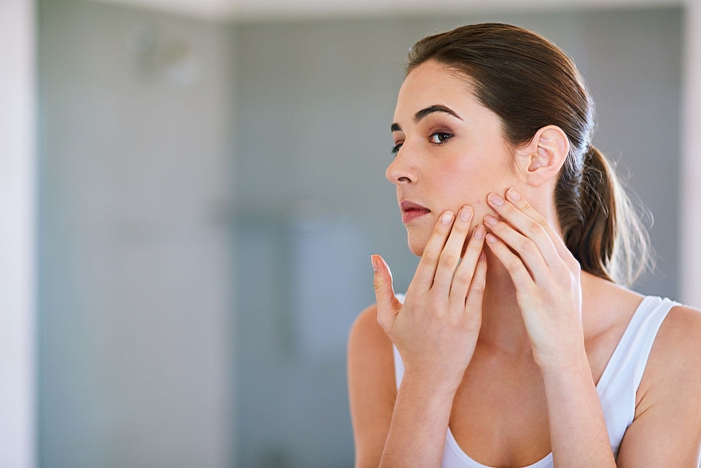 Cropped shot of a young woman squeezing a pimple on her face - Latest Fashion & Lifestyle Trends Treating Acne-Prone Skin