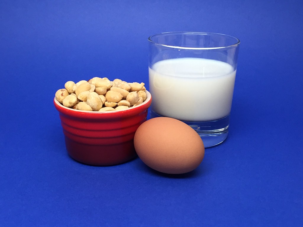 picture of a milk glass, eggs and peanuts in a bowl