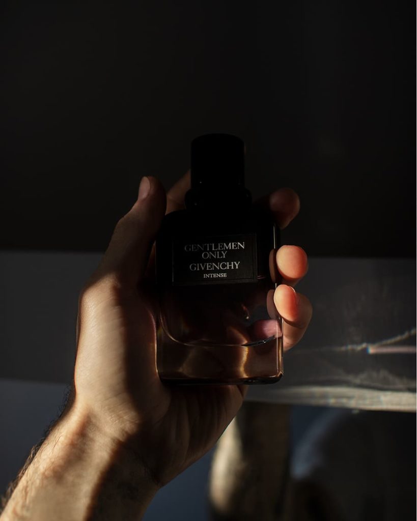 hand holding givenchy perfume bottle